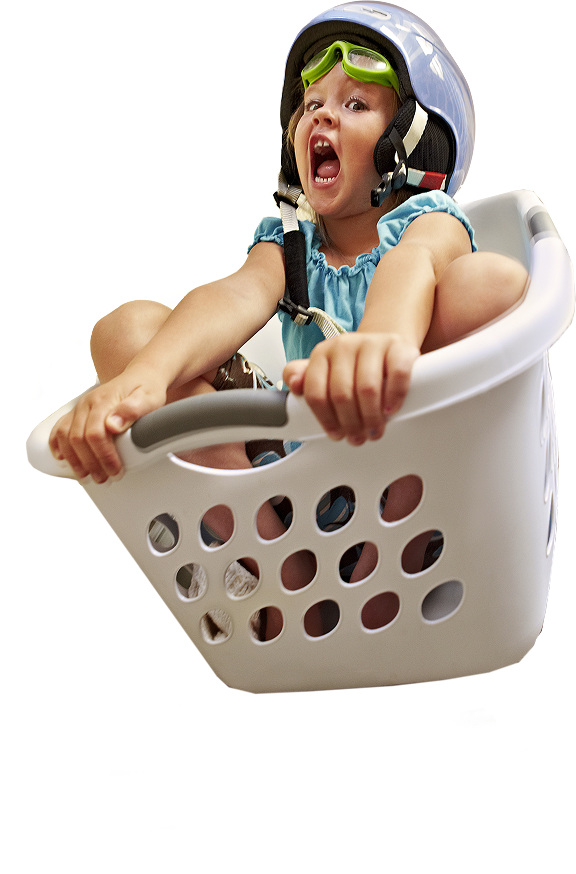 Playful child wearing goggles and helmet in a laundry basket, representing home care ease with ZELSUVMI